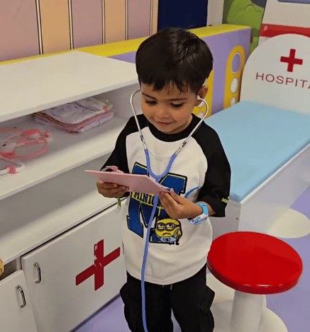 Child enjoying a pretend medical play activity at Wooray Patna indoor play area.
