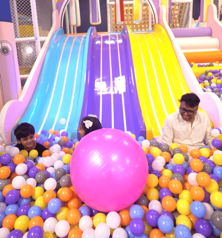 Children enjoying a colourful indoor slide and ball pit at Wooray Patna play area.